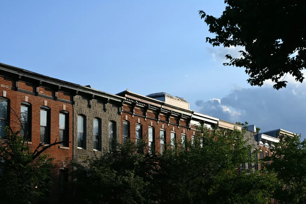 Row of brick rowhouses on a tree-lined street